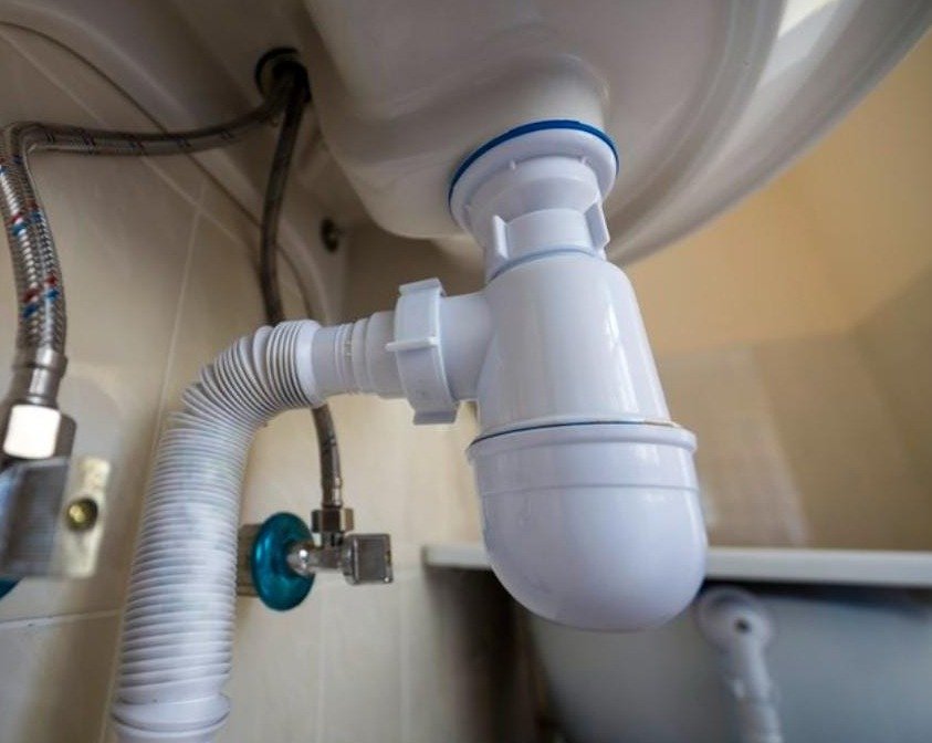Detalle de instalación de sifón y conexiones de fontanería realizado por Obrax